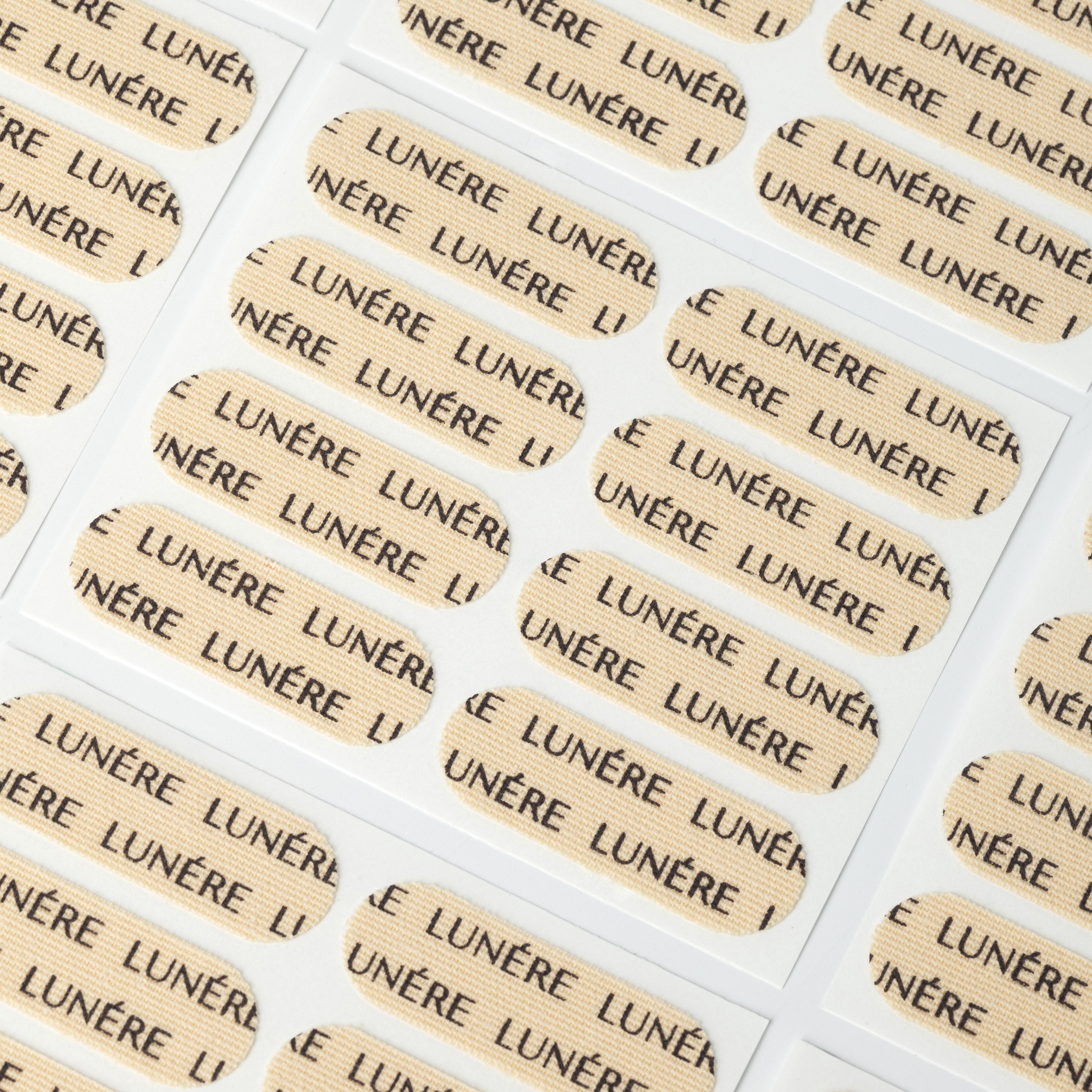 LUNÉRE peptide-infused face tape strips on a sheet, ideal for overnight skin support.